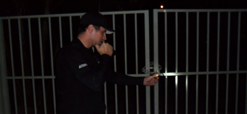 security guard checking lock on gate